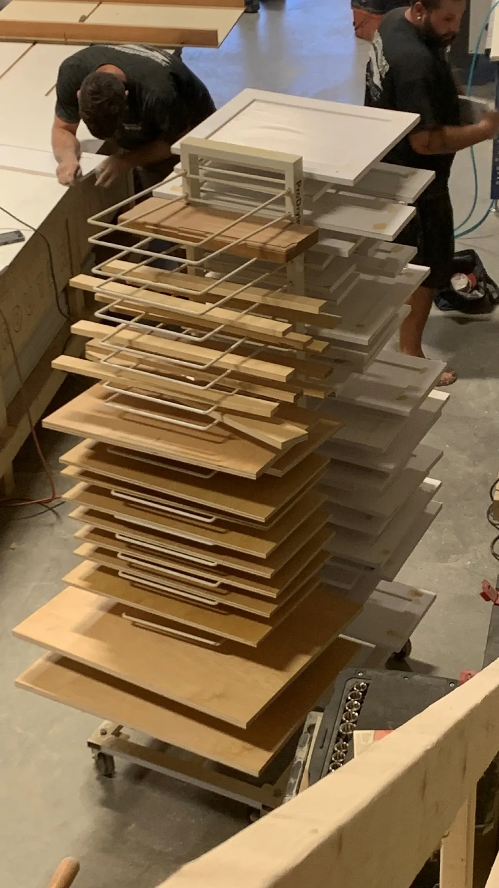 Cabinet door panels stacked on a drying rack